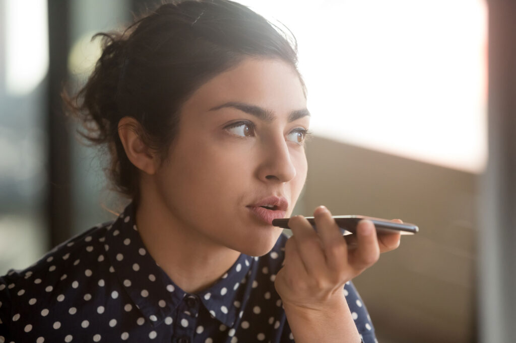 Woman with dark hair talking into her cell phone. 