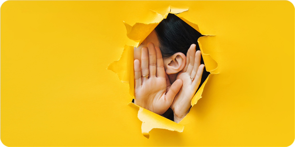 Yellow paper with an ear and two hands poking through to represent listening. 